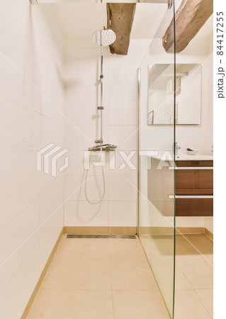 Luxurious shower cubicle with glass partition and modern tap 84417255
