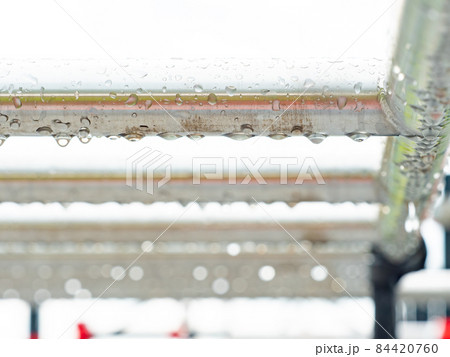 Detail of stainles steel construction with rain drops. 84420760