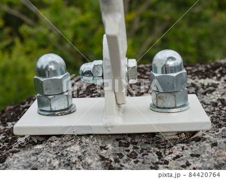 Detail of zinc coated cup head nuts screwed on screw anchors 84420764