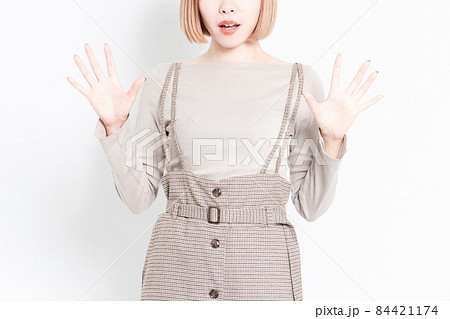 白背景の前に立って驚いたポーズをしている若い女の子 白背景の前に立って驚いたポーズをしている若い女の子 84421174
