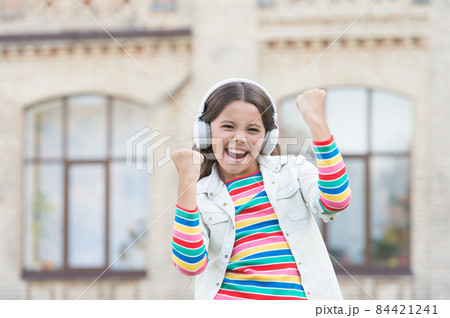 Happy energetic girl listening music modern headphones, joy and happiness concept 84421241