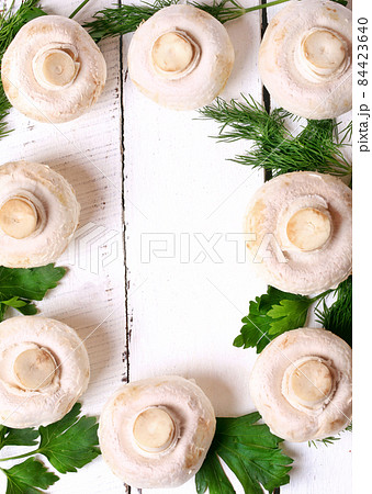 frame of mushrooms champignons on a white wooden background flat top view over head cover cookbook 84423640