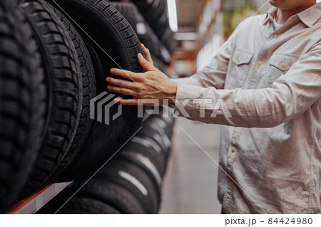 male customer choosing new tires in the supermarket . male customer choosing new tires in the supermarket . 84424980