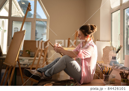 Female artist working in studio. Creative workspace, painting class, easel with canvas, art therapy. Inspiration, creativity, talent, craft concept. Artist studio interior. People, leisure and hobby Female artist working in studio. Creative workspace, painting class, easel with canvas, art therapy. Inspiration, creativity, talent, craft concept. Artist studio interior. People, leisure and hobby 84426101
