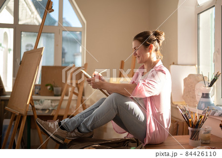 Art, creativity, hobby and creative occupation concept. Bringing creativity to life. Woman painting in art studio. Attractive female artist painting in workshop. Woman hobby, activity, profession Art, creativity, hobby and creative occupation concept. Bringing creativity to life. Woman painting in art studio. Attractive female artist painting in workshop. Woman hobby, activity, profession 84426110