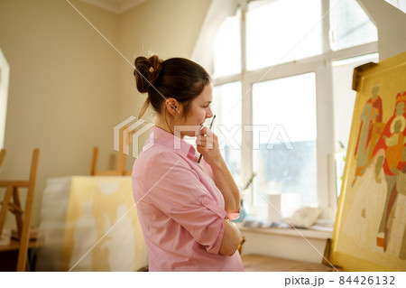 Art, creativity, hobby and creative occupation concept. Bringing creativity to life. Woman painting in art studio. Attractive female artist painting in workshop. Woman hobby, activity, profession 84426132