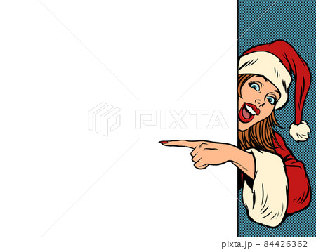 A female Santa Claus points to an empty space for a poster. Christmas and New Year. Winter seasonal holiday 84426362
