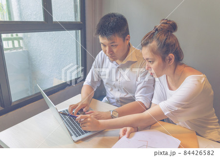 Office man and woman working together on laptop 84426582