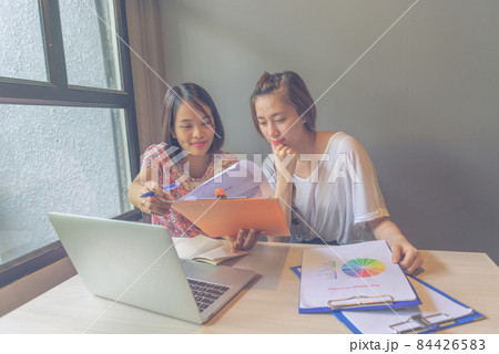 Two office women reading financial document report in the office 84426583