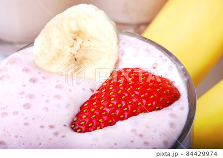 banana and strawberry smoothie on white background 84429974