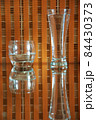 glasses with water and reflections on an orange checkered background 84430373