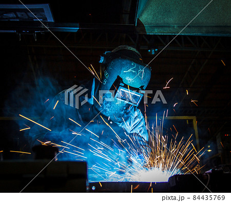 worker with protective mask welding metal 84435769