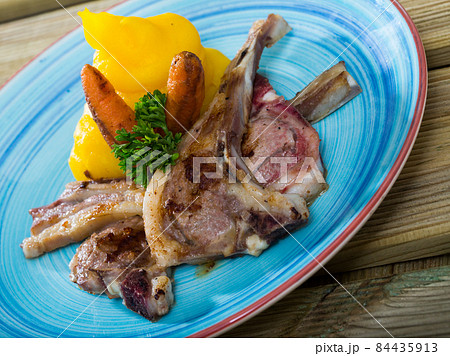 Grilled lamb with mashed jacket potato and mustard at plate with carrots 84435913