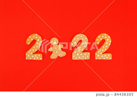 Happy New Year's, Christmas set of numbers 2022, gingerbread man in face mask from ginger biscuits glazed sugar icing decoration on red background, seasonal pandemic winter holiday banner Happy New Year's, Christmas set of numbers 2022, gingerbread man in face mask from ginger biscuits glazed sugar icing decoration on red background, seasonal pandemic winter holiday banner 84436305