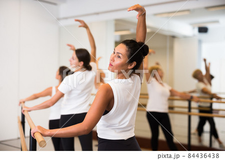 Group of women engaged in ballet in a dance studio performs a choreographic exercise 84436438