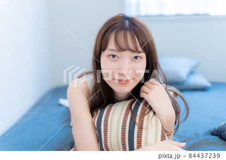 ベッドで寝転びながら微笑む女性 ベッドで寝転びながら微笑む女性 84437239
