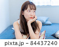 不安げな表情で頬杖をつく女性 84437240