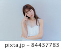 人差し指を頭に当て考えるポーズをする女性 84437783