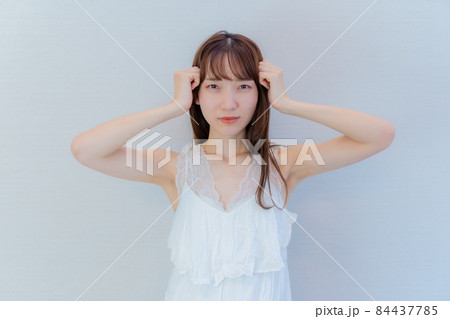 両手を頭に当て困るポーズをする女性 両手を頭に当て困るポーズをする女性 84437785