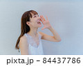 笑顔で呼ぶポーズをする女性 84437786