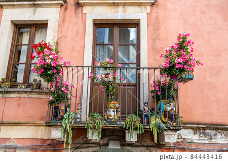 Typical Sicilian balcony in Taormina full of flowers and decorations 84443416