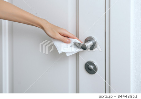 Cleaning door handles with an antiseptic wet wipe and gloves. Woman hand using towel for cleaning home room door link. Sanitize surfaces prevention in hospital and public spaces against corona virus. Cleaning door handles with an antiseptic wet wipe and gloves. Woman hand using towel for cleaning home room door link. Sanitize surfaces prevention in hospital and public spaces against corona virus. 84443853