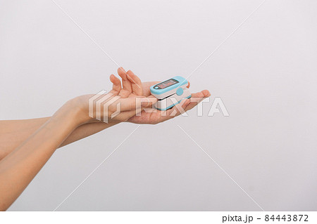 Pulse oximeter with hand of doctor isolated on white. Measuring oxygen saturation, pulse rate and oxygen levels. The concept of portable digital device to measure person's oxygen saturation. Pulse oximeter with hand of doctor isolated on white. Measuring oxygen saturation, pulse rate and oxygen levels. The concept of portable digital device to measure person's oxygen saturation. 84443872