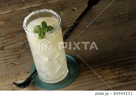 グラスの縁に塩が付いてるミント入りカクテルのソルティドッグ 84444251
