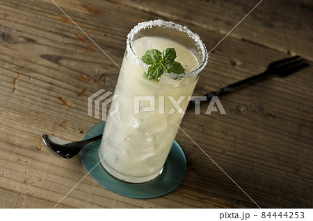 グラスの縁に塩が付いてるミント入りカクテルのソルティドッグ 84444253