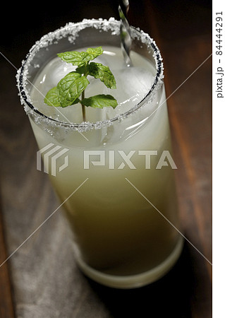 グラスの縁に塩が付いてるミント入りカクテルのソルティドッグ グラスの縁に塩が付いてるミント入りカクテルのソルティドッグ 84444291