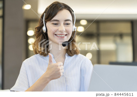 パソコンの画面に向かって親指を上げる笑顔の外国人女性 84445611