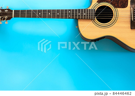 Acoustic guitar on a blue background, top view, copy space. 84446462