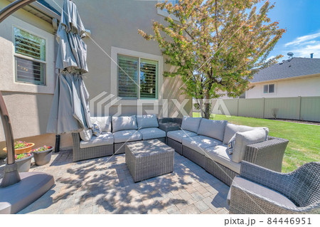 Outdoor patio with woven couch and arcmchair near the tree Outdoor patio with woven couch and arcmchair near the tree 84446951