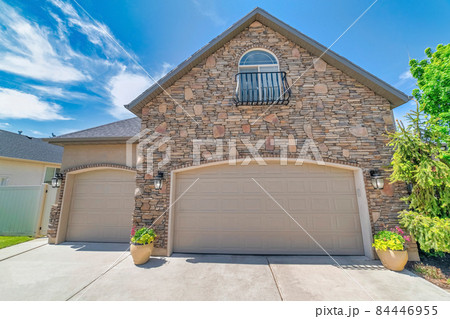 Garage exterior with two garage doors and arched window on top 84446955