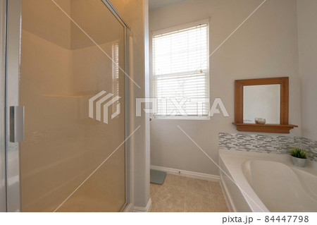 Interior of a bathroom with window and framed mirror 84447798