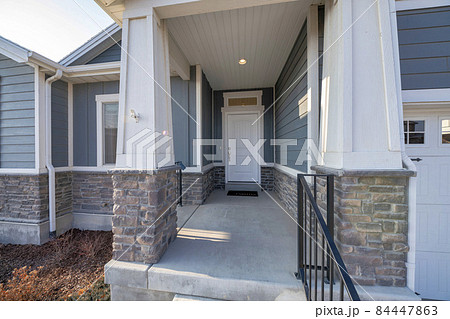 Exterior of an entrance of a house with wooden and stone bricks siding Exterior of an entrance of a house with wooden and stone bricks siding 84447863