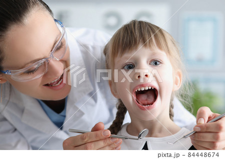 Cute kid visiting family doctor and open mouth pediatrician with tool check hurting throat Cute kid visiting family doctor and open mouth pediatrician with tool check hurting throat 84448674