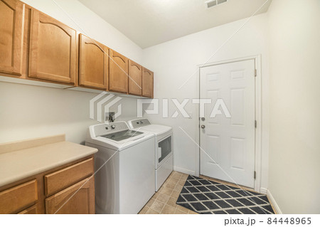 Laundry room with wooden wall cabinets and drawers Laundry room with wooden wall cabinets and drawers 84448965