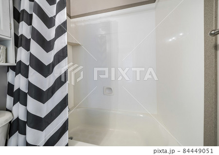 Shower and bathtub set inside a bathroom with shower curtain 84449051