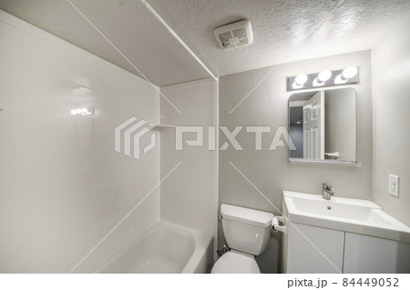 Small all white bathroom interior with vanity sink and mirror 84449052