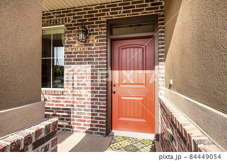 Front door exterior with red brick walls and window 84449054