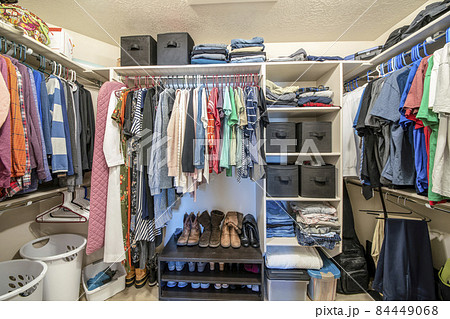 Organized small walk in wardrobe with clothes and linen storage boxes 84449068