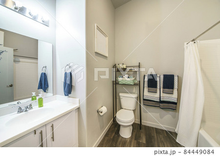 Bathroom interior with over-the-toilet storage rack and wooden flooring Bathroom interior with over-the-toilet storage rack and wooden flooring 84449084