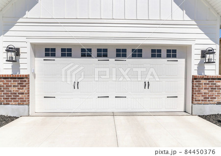 Garage entryway exterior with wall mounted lamp on both sides Garage entryway exterior with wall mounted lamp on both sides 84450376
