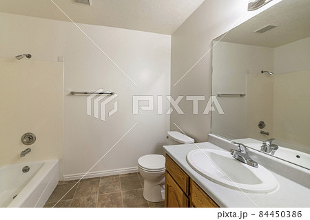 Inside a tile flooring bathroom with vanity sink and shower tub combo 84450386