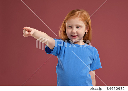 Portrait of cute redhead emotional little girl on red background 84450932