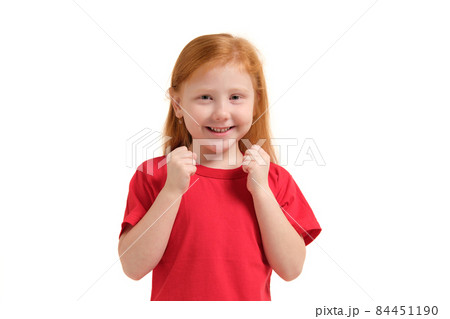 Cheerful little girl, look so excited she is raising her fists up, isolated on white background. Cheerful little girl, look so excited she is raising her fists up, isolated on white background. 84451190