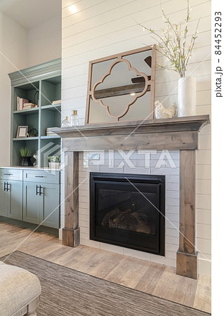 Fireplace and cabinet inside home living room with wood floor and white wall 84452293