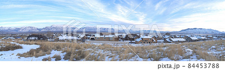 A panoramic view of houses with the mountains in the background 84453788