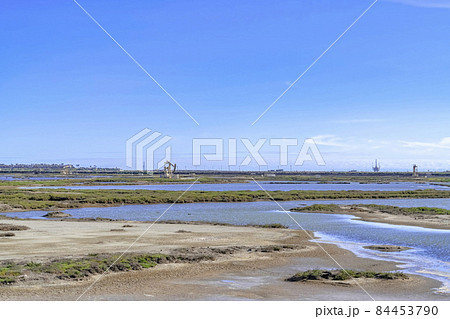 Bolsa Chica Ecological Reserve wetland landscape with distant oil rig machinery 84453790